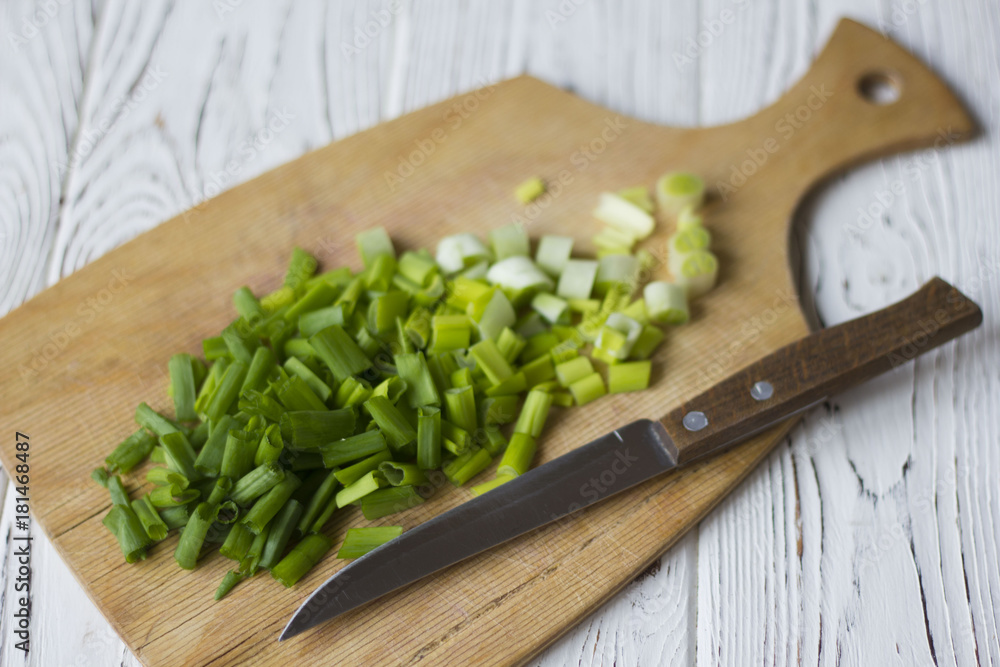 sliced green onions, knife on a wooden table sliced green onions, knife on a wooden table