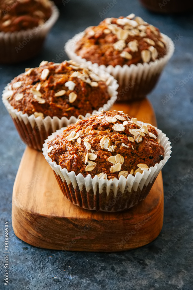 Carrot cake muffins with nuts, raisins and oats on a blue stone background. Carrot cake muffins with nuts, raisins and oats on a blue stone background.