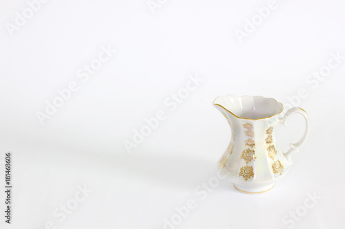 Table set with golden patterns. Set of white dishes on table on light background