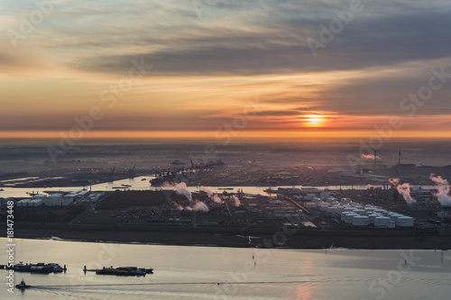 Sunrise over the Port of Antwerp with the Scheldt river and vessels in the foreground and the delwaide dock with the MSC terminal in the background photo