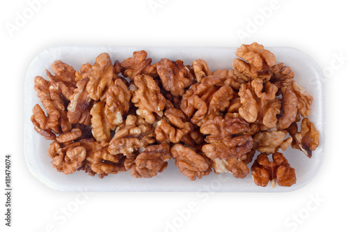 Walnut kernel halfs in a container on white background