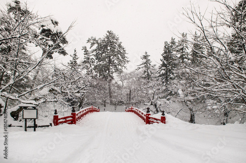 Old red wooden bridge of Hirosaki Castle in winter season, Aomori, Tohoku, Japan photo