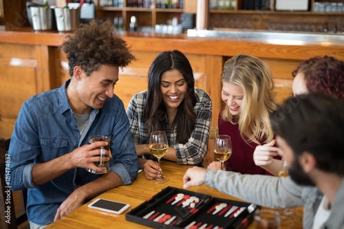 Quadro em tela Friends playing backgammon while having drinks in bar