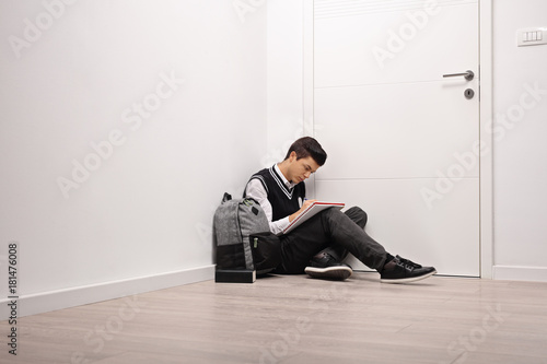 Sad teen student writing in a notebook indoors © Ljupco Smokovski