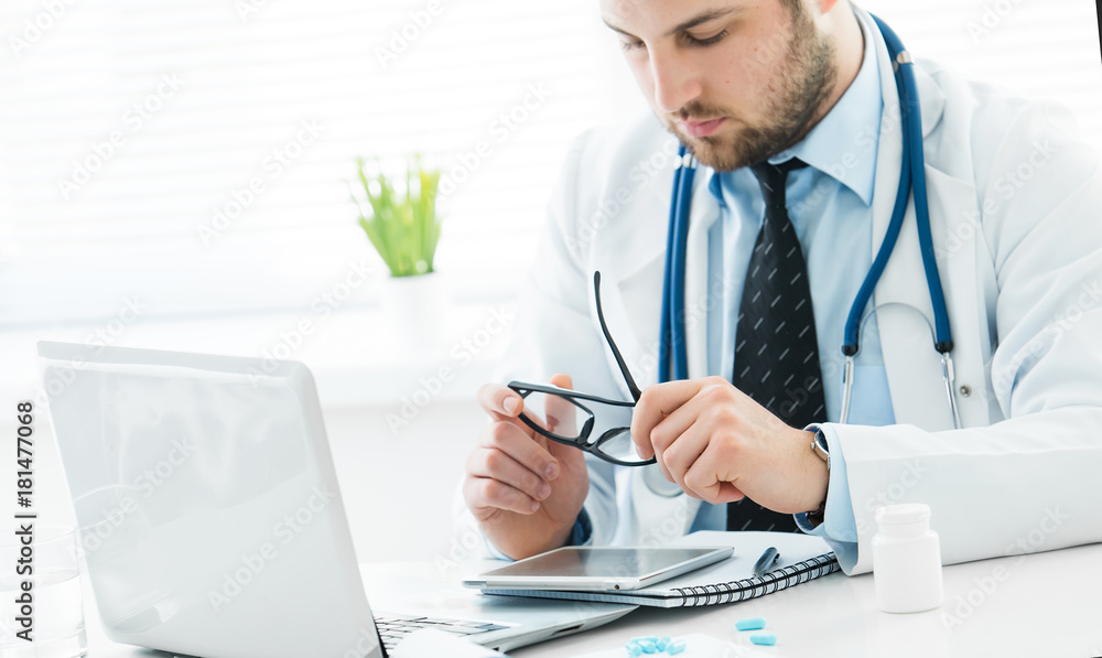 The doctor prescribes a prescription medication sitting in his office