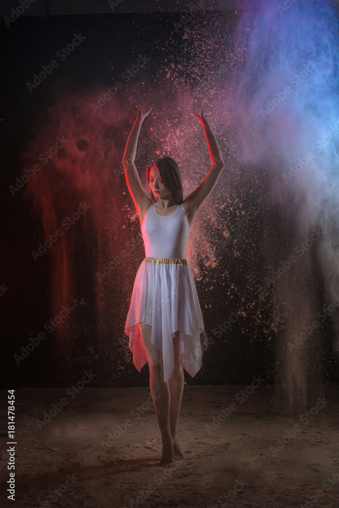 Beautiful slim female dancer in studio during Powder Photo Shoot with colored light