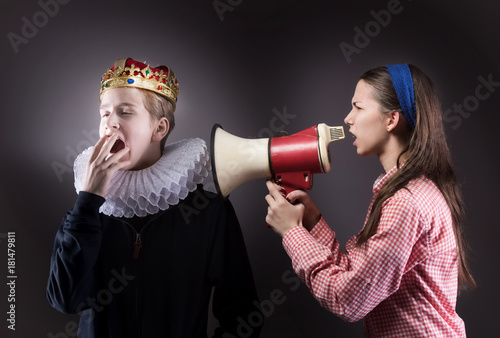 Crowned boy ignores the girl. Difficult teenager comminication concept. photo