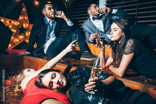 Photography Friends at club lying on the floor and cheers after party having fun