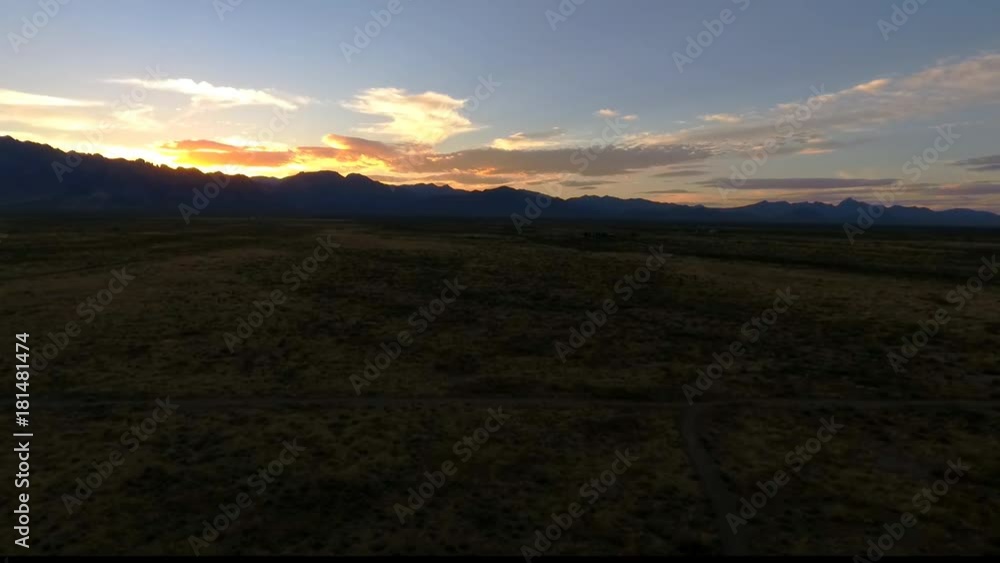 Aerial view of a colorful desert sunset behind distant mountains Aerial view of a colorful desert sunset behind distant mountains