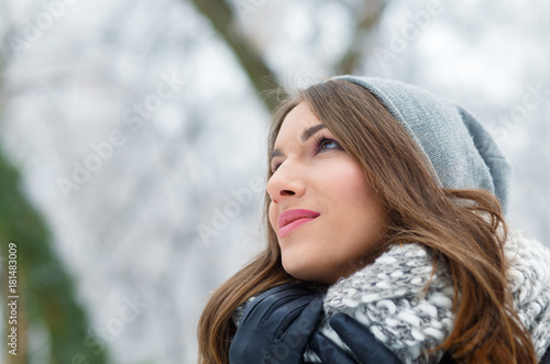 Winter portrait of beautiful young woman in park.
