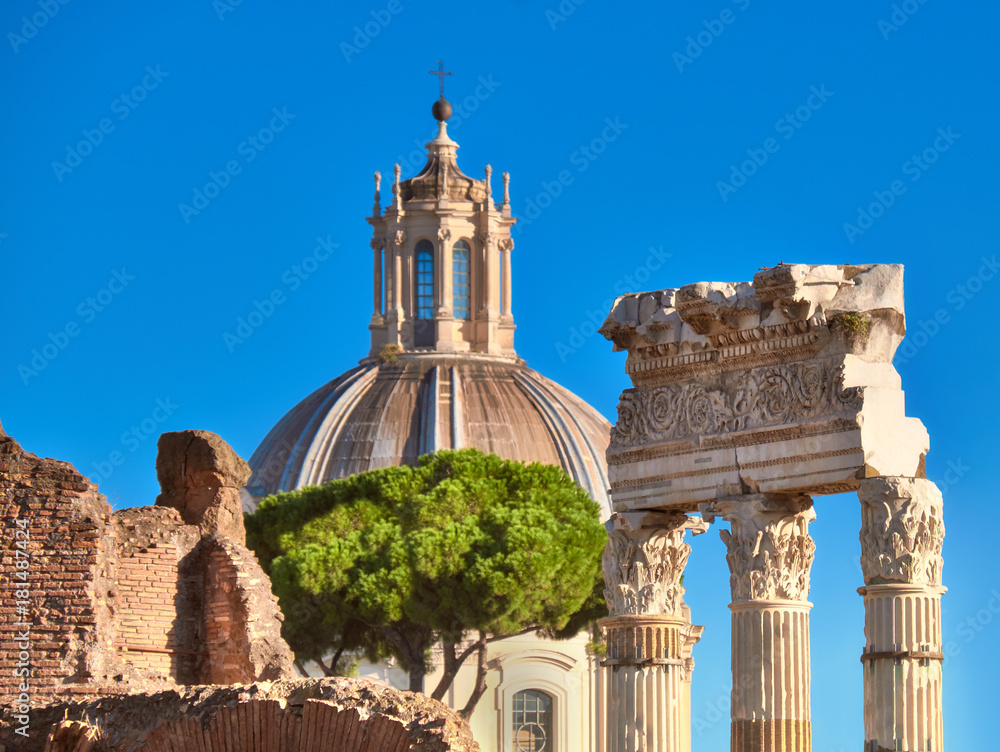 Closeup on columns of Roman Forum with church cupola in Rome, Italy