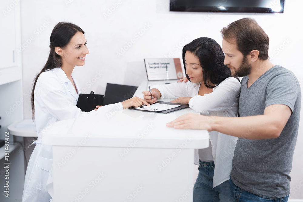 Fototapeta premium A man and a woman came to see a dentist. They fill in the necessary papers in the waiting room.