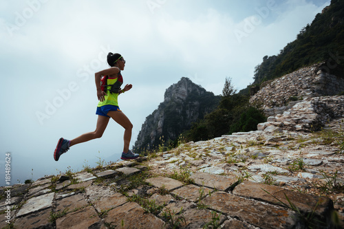 young woman trail runner running on the great wall photo