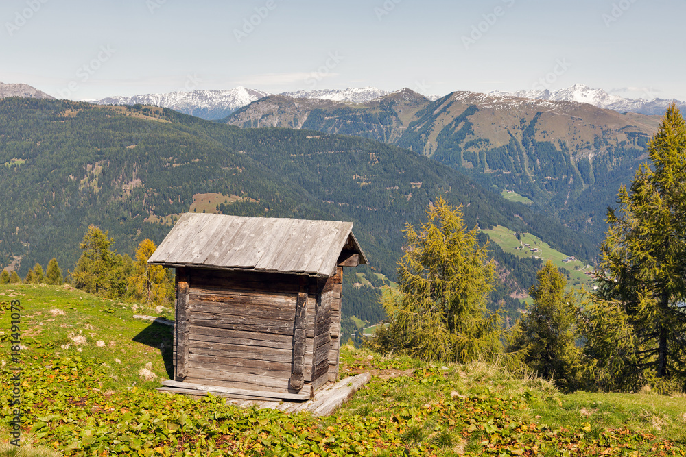 Wooden shepherd toilet with Alpine mountain landscape in Austria.