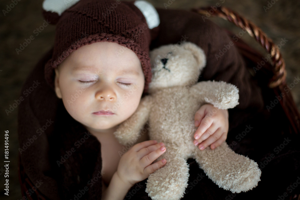 Cute three months old baby with bear hat in a basket, sleeping Cute three months old baby with bear hat in a basket, sleeping