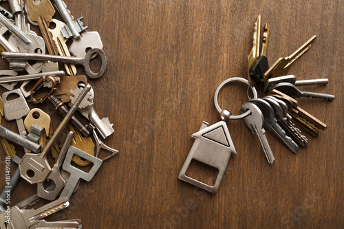 Bunch of keys with house trinklet on wooden table photo