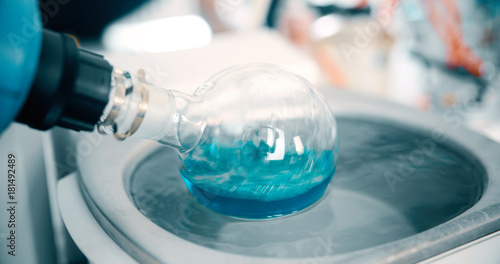 Fotografie Mechanical stirring, liquid of green color is mixed in a round flask