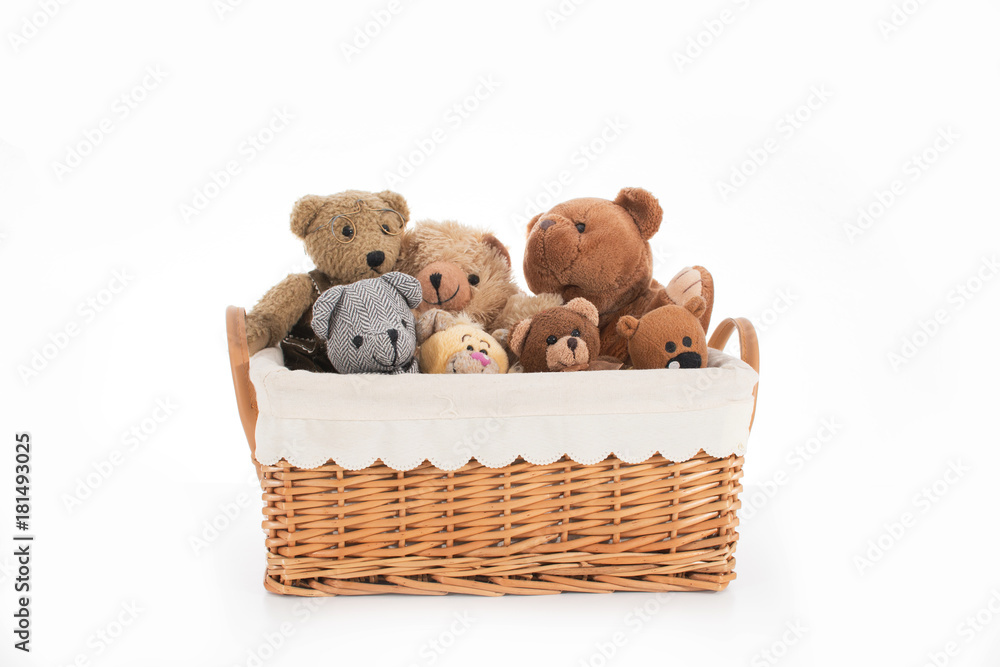 Teddy bears in a straw basket on a white background