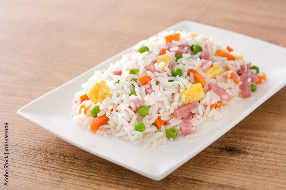 Chinese fried rice with vegetables and omelette on wooden table. Chinese fried rice with vegetables and omelette on wooden table.