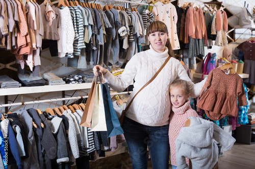 Positive pregnant mother and girl enjoying purchases © JackF