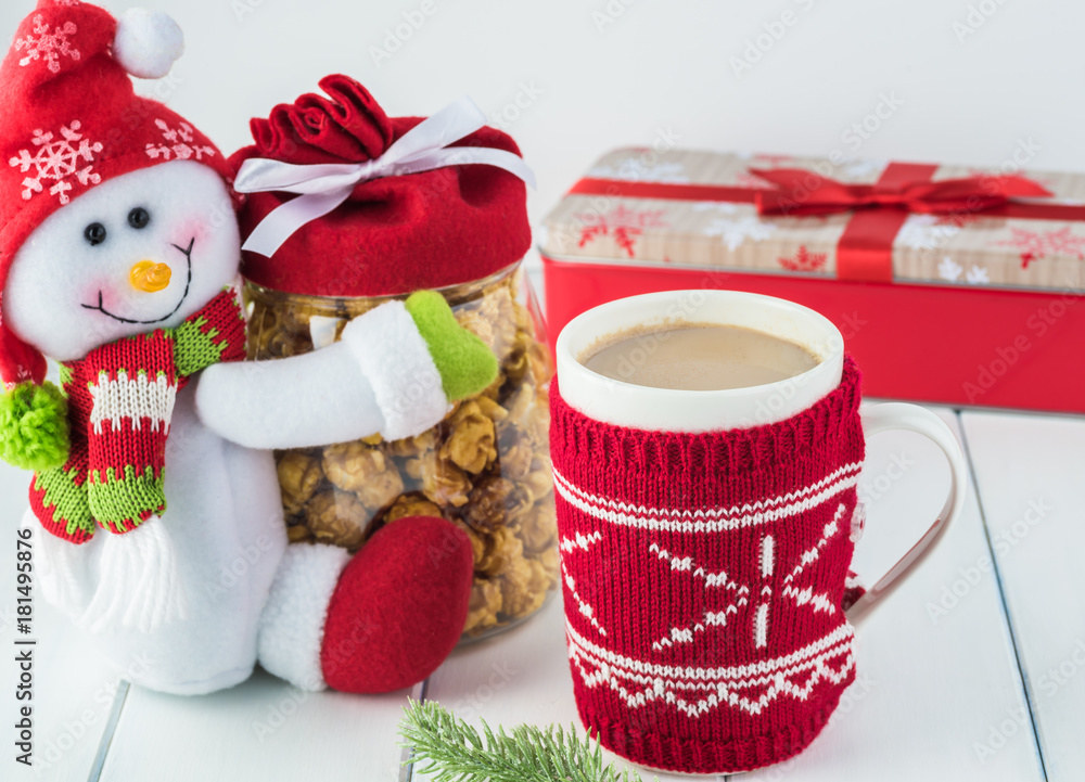 Christmas cover mug with hot cocoa with milk and snowman jar with popcorn.