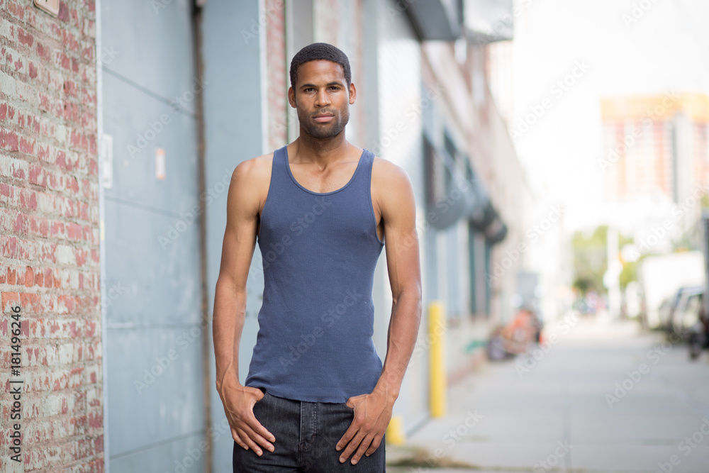 Young handsome African American man in tank top in the rough neighborhood