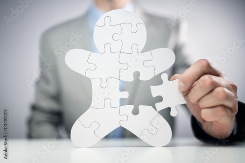 Fototapeta Businessman assembling jigsaw puzzle human team employee