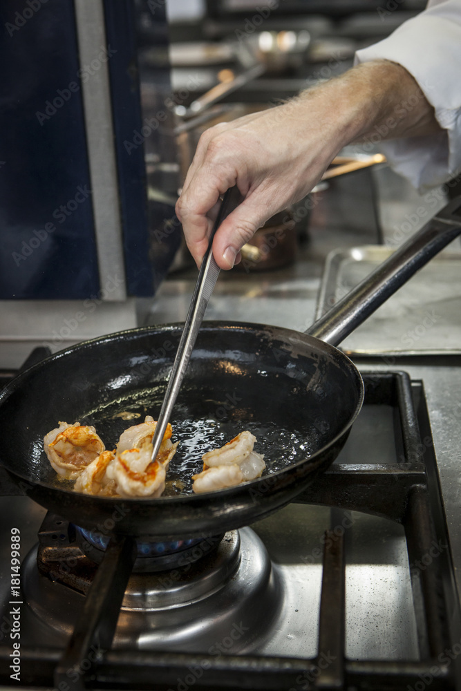 Chef Cook preparing seafood on a stove Chef Cook preparing seafood on a stove