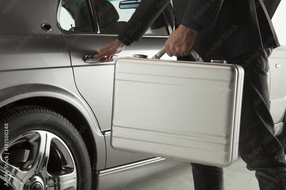 Close-up of man in formalwear opening a car door with a briefcase Close-up of man in formalwear opening a car door with a briefcase