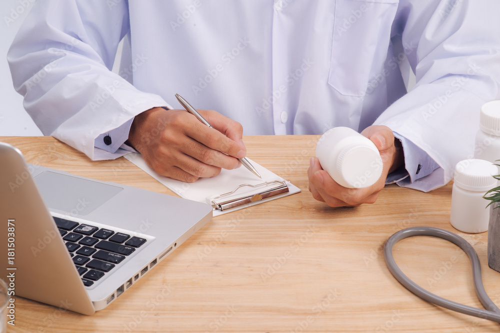 Stethoscope, medical prescription form are lying against the background of a doctor and patient discussing health exam results. Stethoscope, medical prescription form are lying against the background of a doctor and patient discussing health exam results.