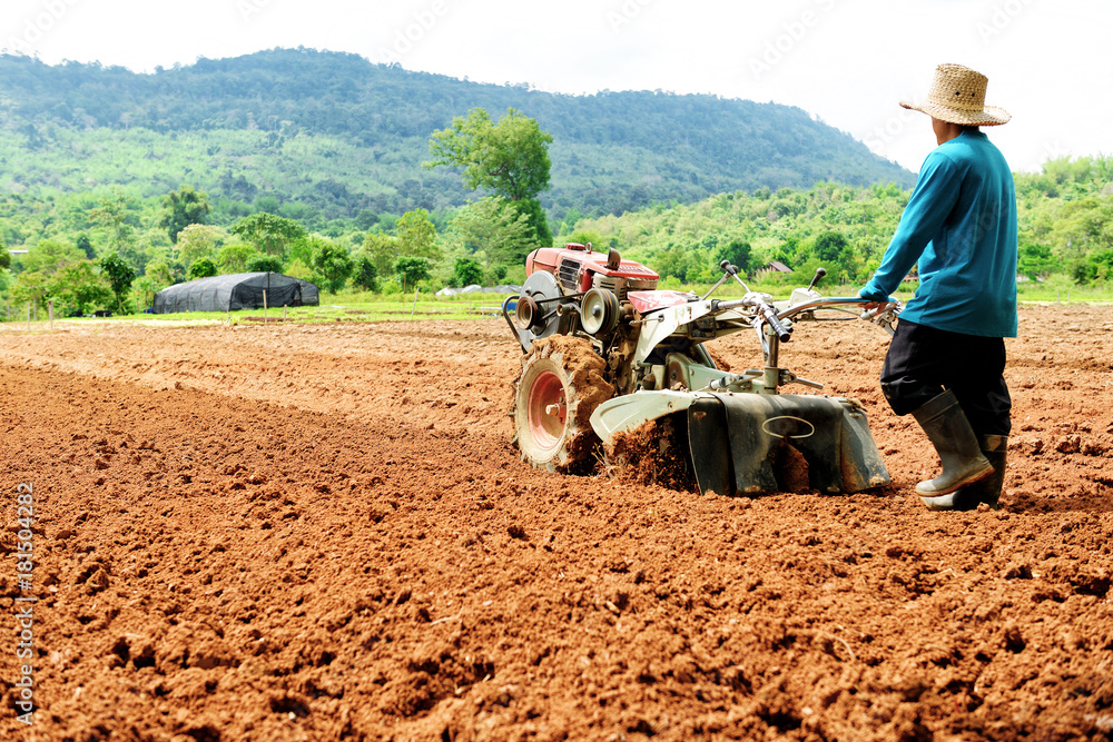 Obraz premium Farmer plowing the field. Cultivating tractor in the field