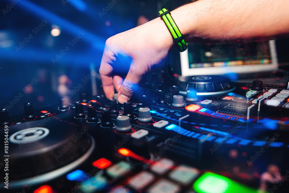 Obraz premium professional panel DJ mixer with hand controlling mixing music in nightclub