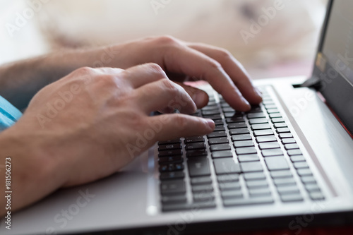 Man s hands typing on laptop notebook keyboard at home. Man browsing information on internet. Freelance blogging  it support concept.