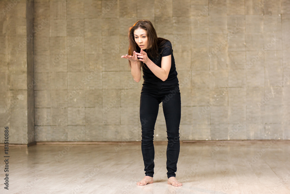 Young female dancer in action. Young beautiful dancer woman performing dance element on studio background. Young female dancer in action. Young beautiful dancer woman performing dance element on studio background.