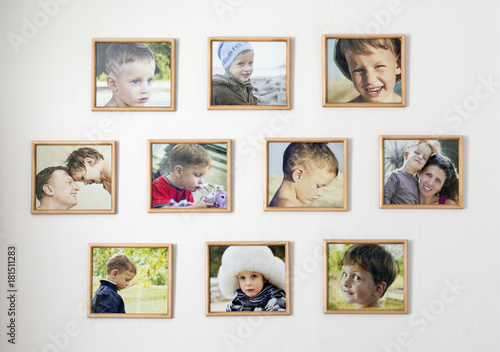White wall with photos of the family in photo frames. Kid room concept.