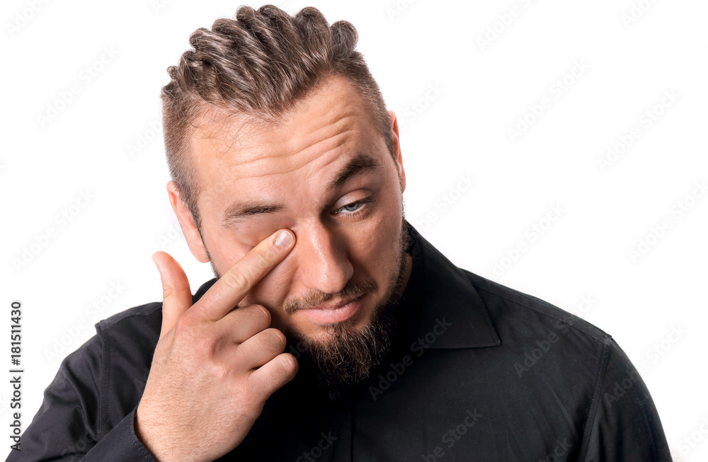 Mann ist müde und reibt sich das Auge Mann ist müde und reibt sich das Auge