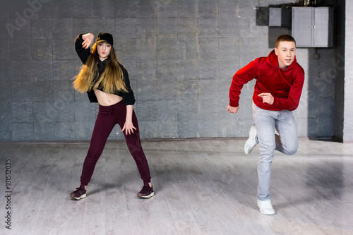 Couple of talented dancers performing hip-hop. Guy and girl dancing contemporary dance i studio. School of hip-hop culture.