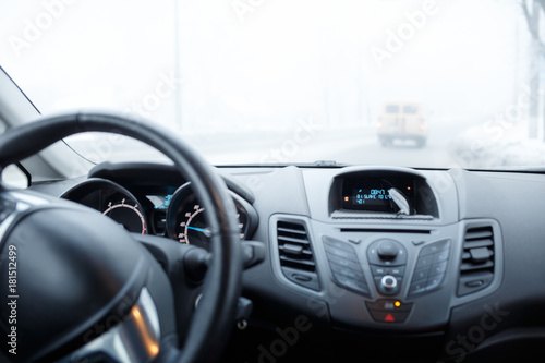 Bad weather driving in winter. Blizzard and fog on the road with low visibility © skumer