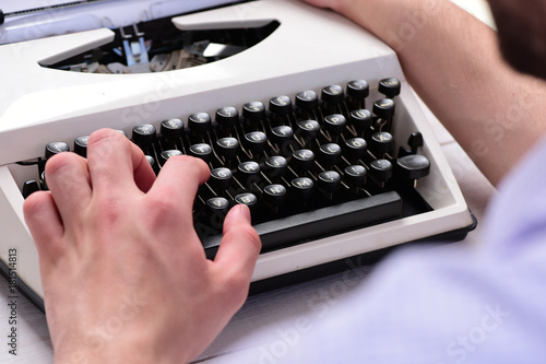 Writer typing with retro writing machine. Old typewriter