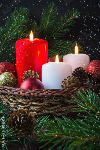 Christmas red balls, candles, spruce branches, wreath and snowflakes on a dark background Decoration for a New Year's holiday with a copy space