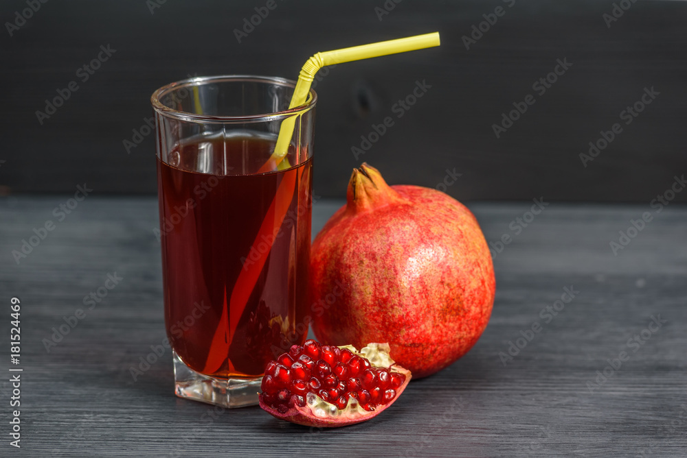 glass beaker with pomegranate juice and pomegranate fruits on a dark wooden background glass beaker with pomegranate juice and pomegranate fruits on a dark wooden background