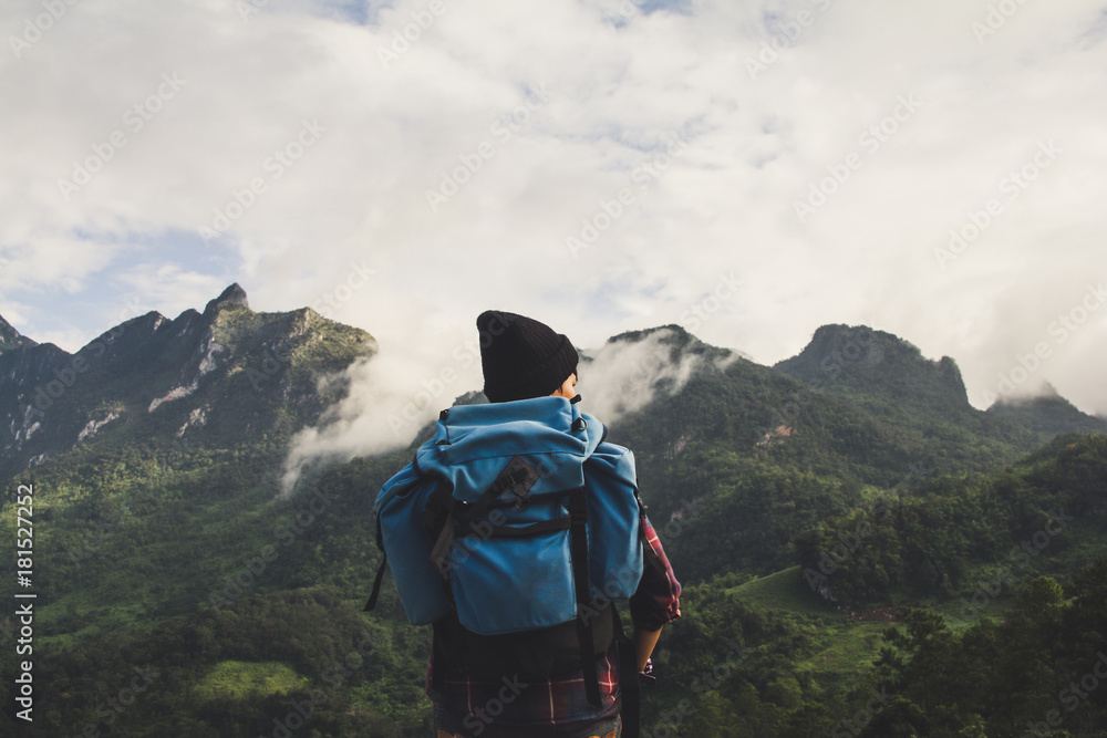 Asian young man in Scottish shirt and black hat hiking at mountain peak above clouds and fog Hiker outdoor. Doi Luang Chiang Dao Chiangmai Province,In morning. Asian young man in Scottish shirt and black hat hiking at mountain peak above clouds and fog Hiker outdoor. Doi Luang Chiang Dao Chiangmai Province,In morning.