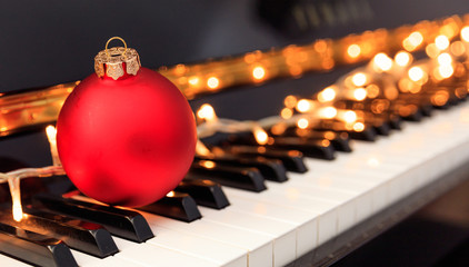Christmas ball and lights on a piano keyboard