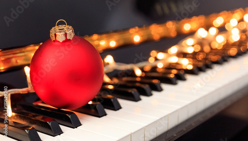 Fototapeta Christmas ball and lights on a piano keyboard