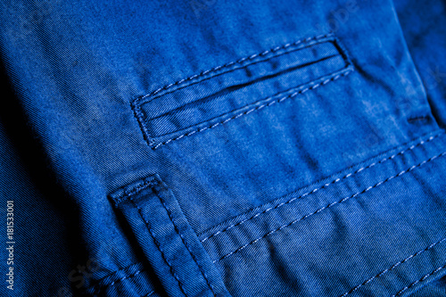 Blue jeans texture background dark denim back pockets low light Leather label sewed on blue jeans textile Close up space for text. photo