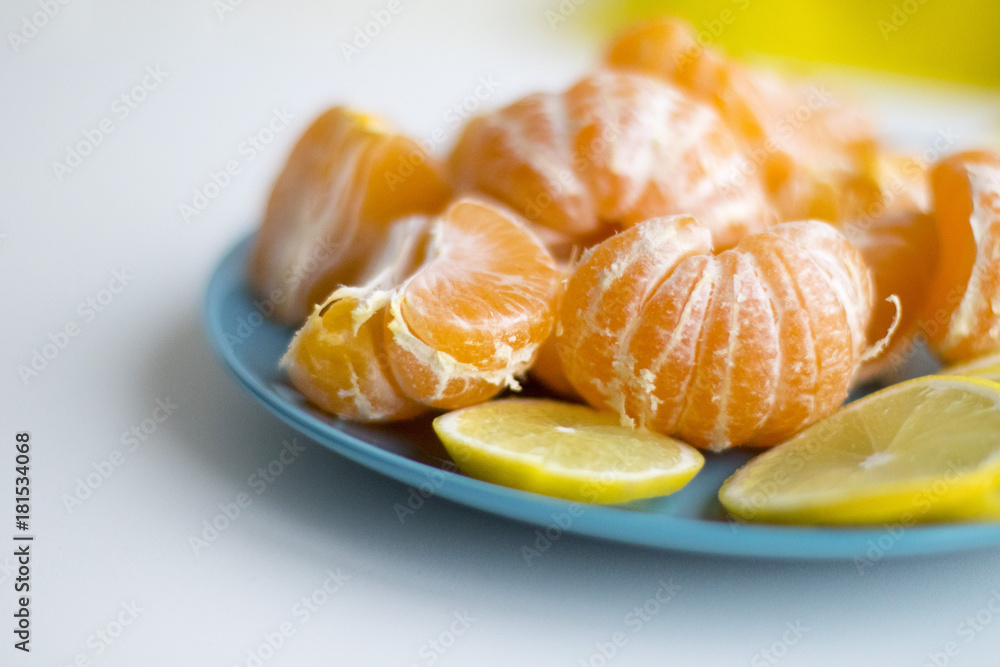 Blue plate with sliced lemon and tangerine Blue plate with sliced lemon and tangerine