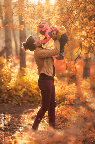 Happy family mother and child daughter playing in nature autumn park on sunset  © Evgeniya Grande