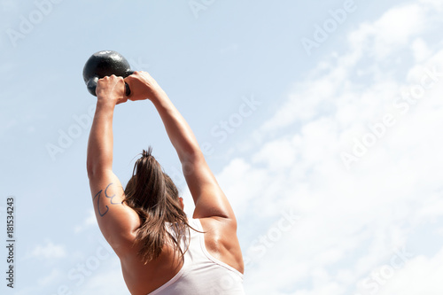 Young woman doing kettlebell swings at crossfit competition
