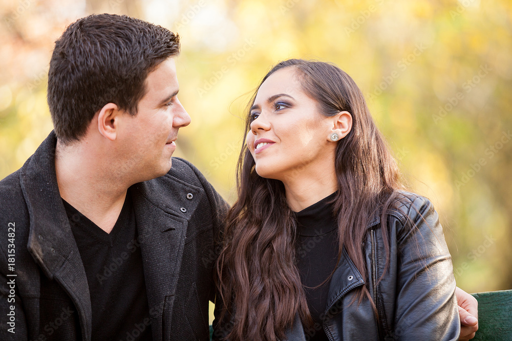 Close up of beautiful in love couple sitting on a bench in autumn park Close up of beautiful in love couple sitting on a bench in autumn park