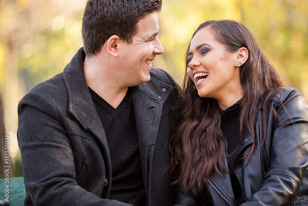 Close up of beautiful in love couple sitting on a bench in autumn park Close up of beautiful in love couple sitting on a bench in autumn park